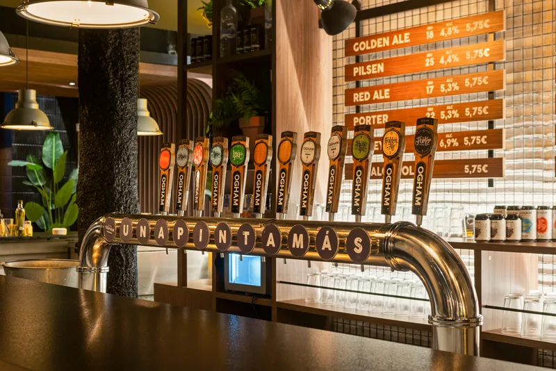 El muro de doce grifos de cerveza detrás de la barra